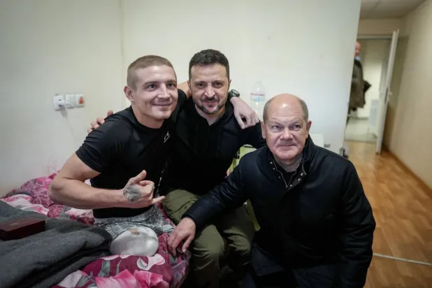 المستشار الألماني أولاف شولتس والرئيس الأوكراني فولوديمير زيلينسكي في كييف في صورة مع أحد الجنود الأوكرانيين الذين أصيبوا في الحرب (د.ب.أ)