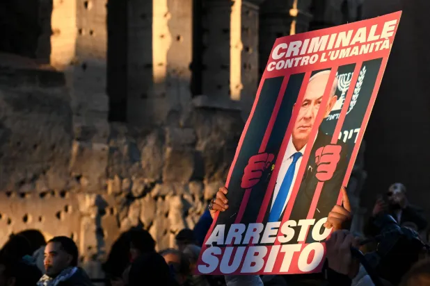 صورة لنتنياهو وراء القضبان خلال تظاهرة مؤيدة للفلسطينيين في روما يوم 30 نوفمبر الماضي (أ.ف.ب)