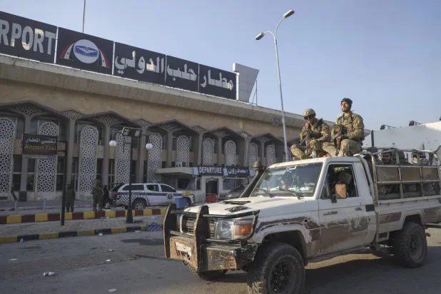 مقاتلون من الفصائل السورية المسلحة في محيط مطار حلب الدولي (أ.ب)