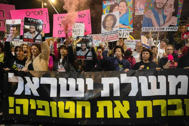متظاهرون إسرائيليون يحملون لافتات خلال احتجاج مناهض للحكومة يطالبون فيها باتخاذ إجراءات للإفراج عن الإسرائيليين المحتجزين رهائن لدى حركة «حماس» في غزة... الصورة بتل أبيب في 30 نوفمبر 2024 (أ.ف.ب)