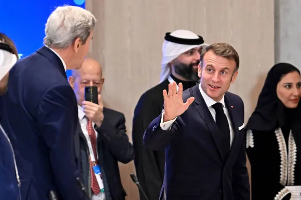 إيمانويل ماكرون (إلى اليمين) يحيي عن بعد وزير الخارجية الأميركي الأسبق جون كيري بمناسبة مؤتمر اقتصادي في الرياض الثلاثاء (أ.ف.ب)