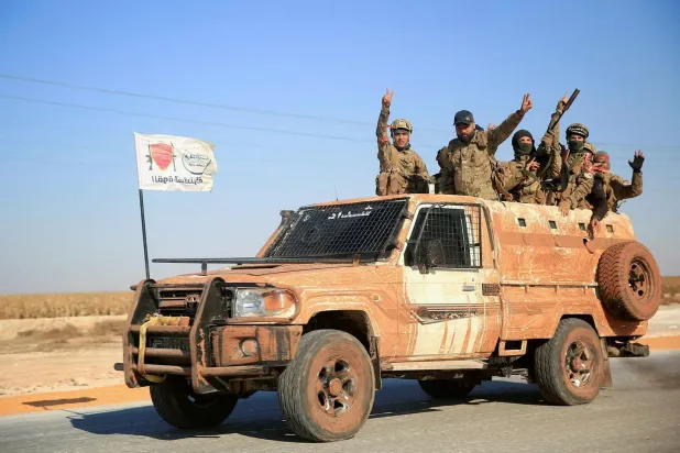 Anti-government fighters ride military vehicles in the eastern part of Aleppo province, in Syria, on Sunday. (Aref Tammawi/AFP)

 