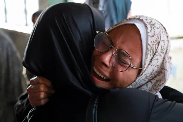 رد فعل امرأة فلسطينية في موقع غارة إسرائيلية على مدرسة تؤوي النازحين بغزة (رويترز)