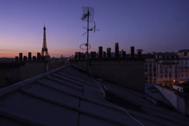 The Eiffel Tower and zinc roofs are seen at sunset in Paris, Thursday, Nov. 28, 2024. (AP Photo/Louise Delmotte)