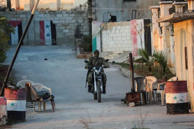 عنصر من «هيئة تحرير الشام» عند نقطة تفتيش في الراشدين بمحافظة حلب 29 نوفمبر (رويترز)