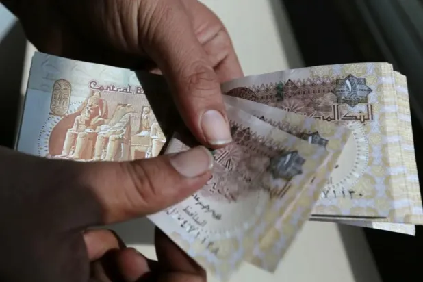 A man counts Egyptian notes outside a bank in Cairo, Egypt - File photo/Reuters
