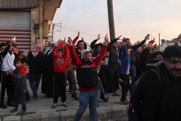 Hükümet karşıtı savaşçılar dün Hama’ya girerken halk tezahürat yapıyor (AFP)