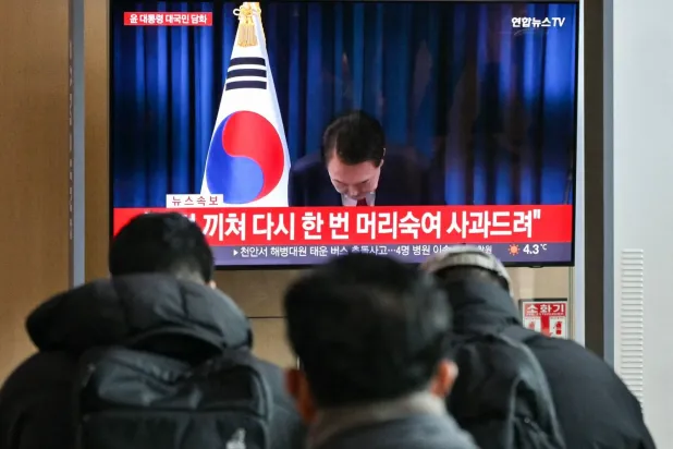  Güney Kore Devlet Başkanı Yoon Suk-yeol, devlet televizyonunda yayınlanan özür konuşmasının ardından selam verdi (AFP)