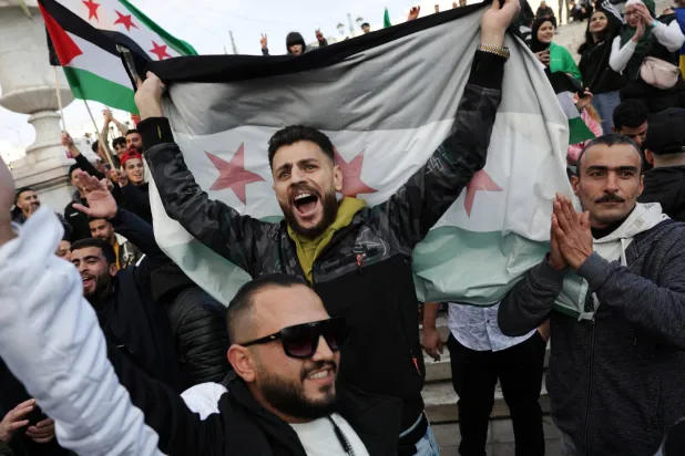 سوريون يقيمون في اليونان يرفعون «علم الثورة» في ميدان سنتغما (رويترز)