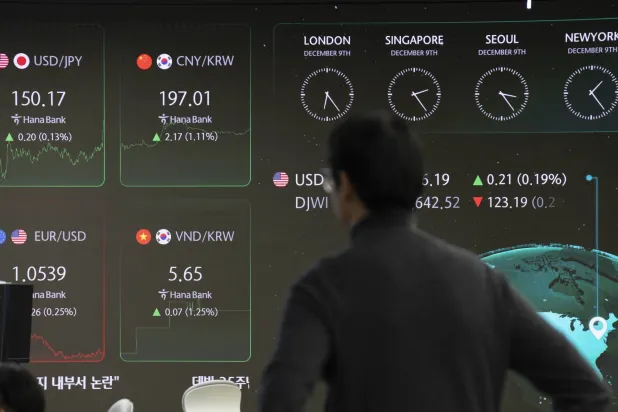 متداول كوري جنوبي يعمل أمام شاشة في بنك «هانا» في سيول (وكالة حماية البيئة)
