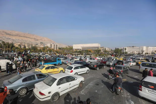 People in Damascus celebrate on December 9, 2024, after opposition fighters declared that they have taken the Syrian capital in a lightning offensive, sending President Bashar al-Assad fleeing and ending five decades of Baath rule in Syria. (Photo by Bakr ALKASEM / AFP)
