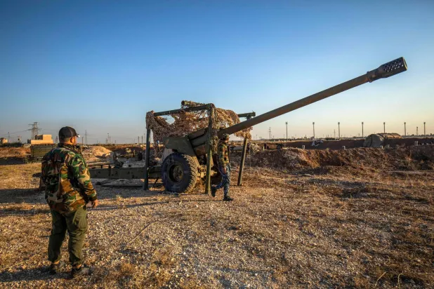 مقاتلون من «قسد» يعاينون مدفع ميدان هجره الجيش السوري في منطقة القامشلي (أ.ف.ب)