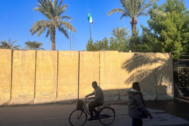 علم المعارضة على مبنى السفارة السورية في بغداد أمس (رويترز)