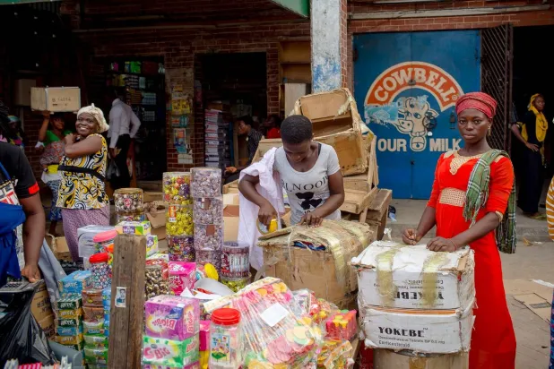 تجار يبيعون بضائعهم بسوق ماكولا في أكرا (رويترز)