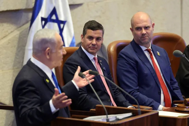 نتنياهو يتحدث خلال جلسة عامة في الكنيست الأربعاء بينما ينظر إليه رئيس باراغواي سانتياغو بينيا ورئيس الكنيست الإسرائيلي أمير أوحانا