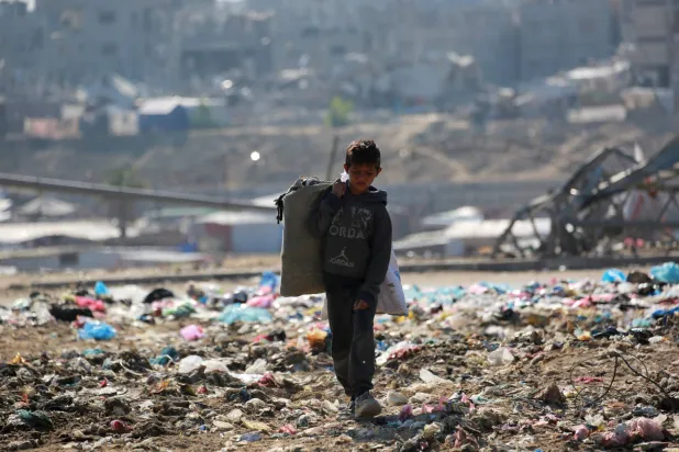 طفل يجمع الخردة من مكبّ جنوب غزة (أ.ف.ب)