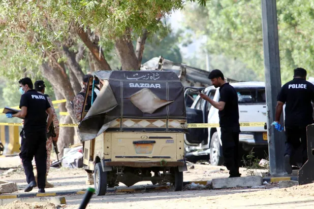 مسؤولون أمنيون يتفقدون موقع انفجار خارج مطار جناح الدولي في كراتشي بباكستان 7 أكتوبر 2024 (إ.ب.أ)