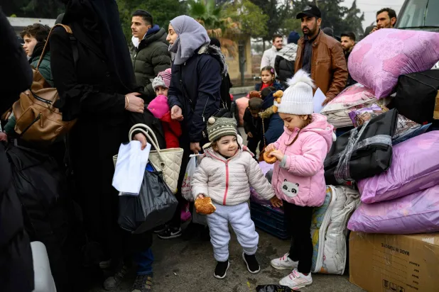 سوريون مقيمون في تركيا ينتظرون لدخول سوريا عند بوابة معبر جيلفي غوزو الحدودي في الريحانية في 12 ديسمبر 2024 بعد الإطاحة بنظام الأسد (أ.ف.ب)