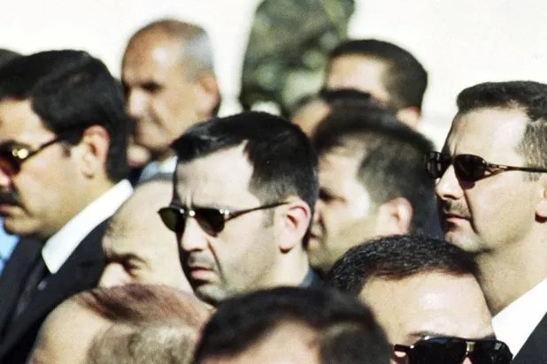 Bashar al-Assad, right, and his brother Maher Assad, center, stand during the funeral of their father, former President Hafez al-Assad, in Damascus, Syria, June 13, 2000. (AP Photo, File) 