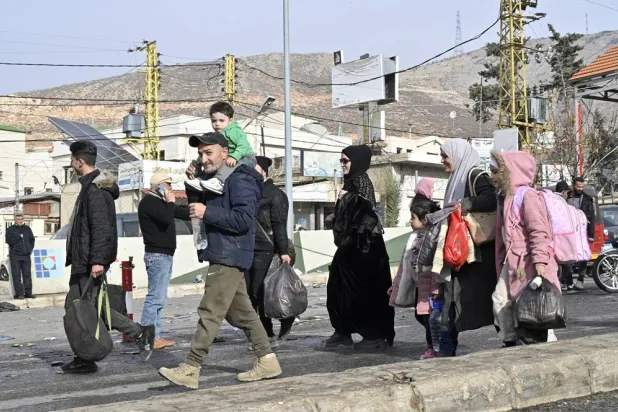 People wait with their belongings at the Al-Masnaa crossing as they prepare to return to Syria, on the Lebanese-Syrian border, Lebanon, 11 December 2024. (EPA)