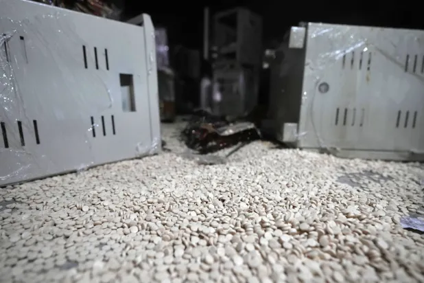 حبوب الأمفيتامين -المعروفة باسم كبتاغون- التي كانت معدة للإخفاء داخل مكونات كهربائية شوهدت في المستودع حيث تم تصنيع المخدرات قبل سقوط حكومة بشار الأسد في منشأة بمدينة دوما (أ.ب)