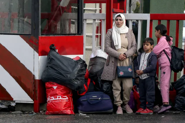 أم سورية مع أطفالها عند معبر المصنع الحدودي بين لبنان وسوريا (د.ب.أ)