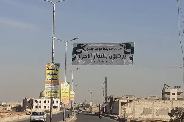 لافتة ترحّب بالثوار معلقة في الطريق الرئيسة المؤدية إلى وسط دوما (الشرق الأوسط)