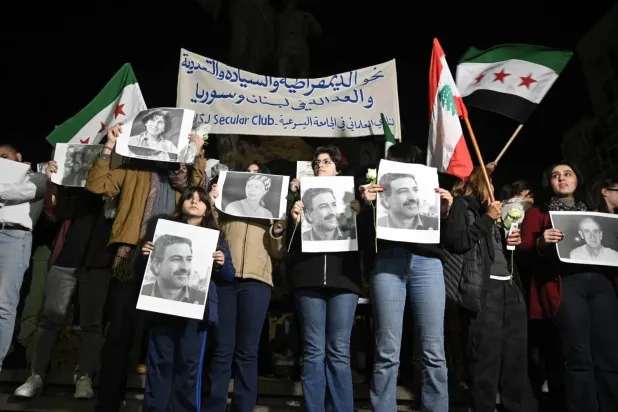  Activists carry Lebanese and Syrian flags, along with pictures of journalist Samir Kassir, who was assassinated by the former Syrian regime, during a demonstration in Beirut (EPA).