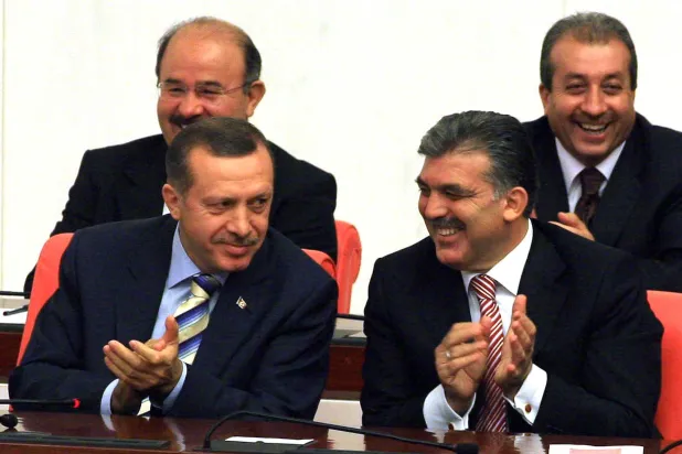 عبد الله غل (يمين) يصفق وهو يجلس بجوار إردوغان (يسار) في البرلمان التركي أغسطس 2007 (غيتي)