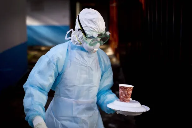 In this Oct. 8, 2014 photo, a medical worker from the Infection Prevention and Control unit wearing full protective equipment carries a meal to an isolation tent housing a man being quarantined after coming into contact in Uganda with a carrier of the Marburg Virus, at the Kenyatta National Hospital in Nairobi, Kenya. (AP)