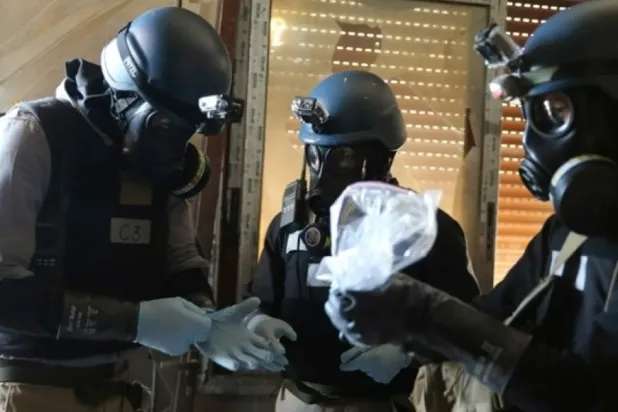 FILE PHOTO: A UN chemical weapons expert, wearing a gas mask, holds a plastic bag containing samples from one of the sites of an alleged chemical weapons attack in the Ain Tarma neighborhood of Damascus August 29, 2013. REUTERS/Mohamed Abdullah
