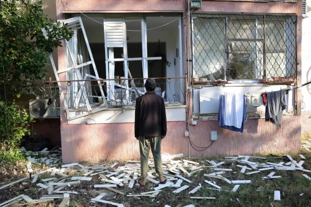 A person inspects damage at the site where a projectile fired from Yemen landed in Tel Aviv on December 21, 2024 (EPA)