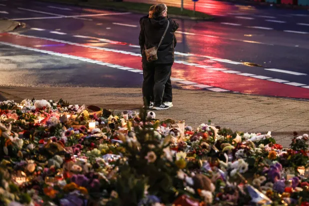 People mourn at the mourning site in front of St. John's Church following a vehicle-ramming attack on the Christmas market in Magdeburg, Germany, 22 December 2024.  EPA/FILIP SINGER