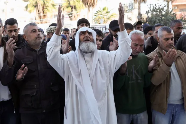 فلسطينيون يؤدون صلاة الجنازة على مواطنين لهم قضوا بغارة إسرائيلية في مستشفى شهداء الأقصى بدير البلح (رويترز)