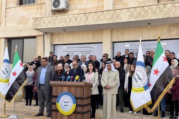 Kuzey ve Doğu Suriye Özerk Yönetimi yetkilileri, Suriye'nin kuzeyindeki Rakka kentinde bulunan merkezlerinin önünde (Şarku'l Avsat)