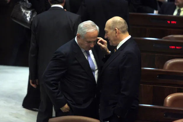رئيس الوزراء الإسرائيلي السابق إيهود أولمرت (يمين) مع رئيس الوزراء الحالي بنيامين في الكنيست 2009 (غيتي)