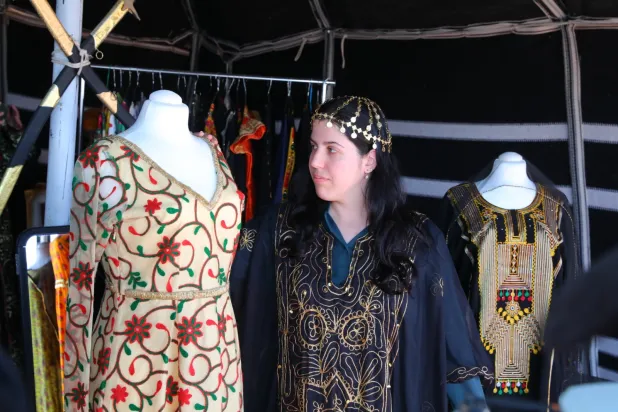 زائرة أجنبية تعاين أزياء تراثية عرضت ضمن الفعاليات المصاحبة للمهرجان (الشرق الأوسط)