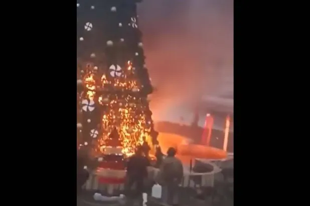 صورة من مقطع فيديو يُظهر سوريين يحاولون إخماد النيران المشتعلة في شجرة عيد الميلاد قرب حماة (المرصد السوري)