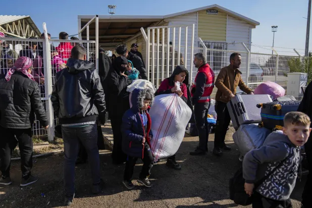 سوريون يعبرون إلى بلادهم من تركيا عند بوابة أونجو بينار الحدودية بالقرب من مدينة كيليس جنوب تركيا (أ.ب)