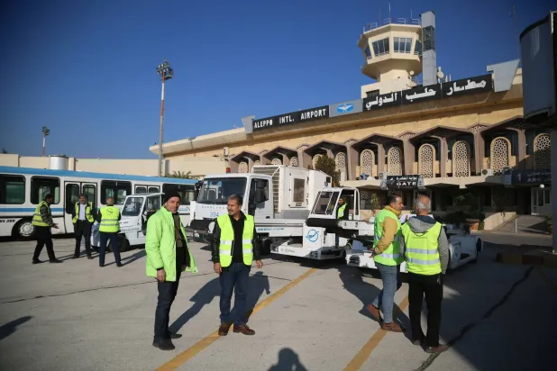 موظفون يعملون في مطار حلب الذي أعيد افتتاحه لأول مرة منذ الإطاحة بنظام بشار الأسد (إ.ب.أ)