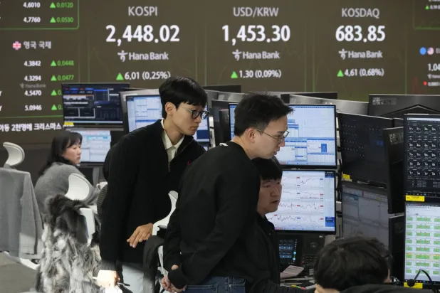 يراقب متداولو العملات شاشات تعرض مؤشر «كوسبي» وسعر صرف الدولار الأميركي مقابل الوون ببنك كيب هانا في سيول (أ.ب)