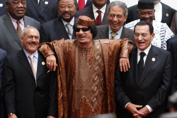 القذافي يتوسط مبارك (يمين) وعلي عبد الله صالح (يسار) ويظهر عمرو موسى ضاحكاً بعد «قمة سرت» عام 2010 (رويترز)