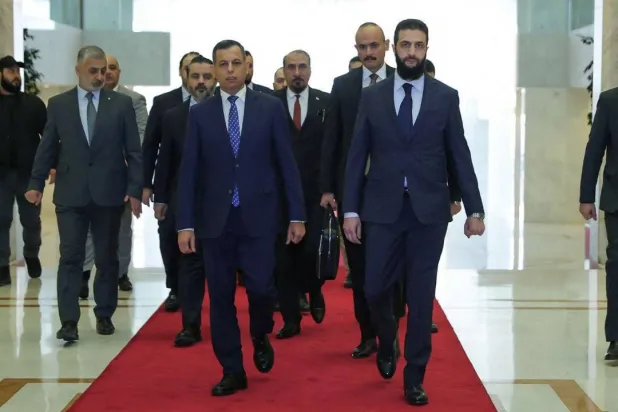 الشرع مستقبلا الوفد العراقي (أ.ف.ب)