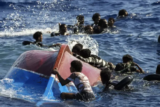 قارب على متنه مهاجرون غير نظاميين خلال غرقه (أرشيفية)
