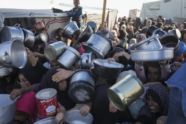 Palestinian women and girls struggle to reach for food at a distribution center in Khan Younis, Gaza Strip Friday, Dec. 6, 2024. (AP Photo/Abdel Kareem Hana, File)

