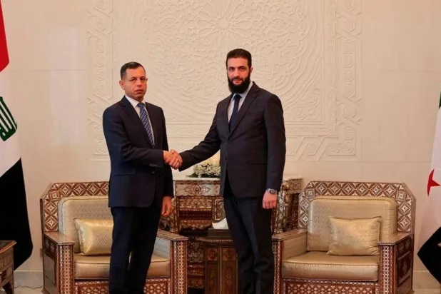 Head of Hayat Tahrir al-Sham and Syria's de facto leader Ahmed al-Sharaa shakes hands with Iraqi National Intelligence Service (INIS) head Hamid Al-Shatri on the day of their meeting in Damascus, Syria December 26, 2024. (Hayat Tahrir Al-Sham/Handout via Reuters) 