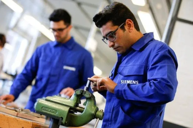 لاجئون يظهرون مهاراتهم في أعمال معالجة المعادن في أحد المعامل الصناعية الألمانية في برلين ألمانيا 2016 (رويترز)