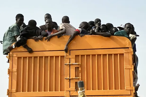 فارون من المعارك ينقلون بشاحنات من مدينة رينك الحدودية في جنوب السودان إلى رصيف لمواصلة رحلتهم إلى وجهتهم التالية (د.ب.أ)