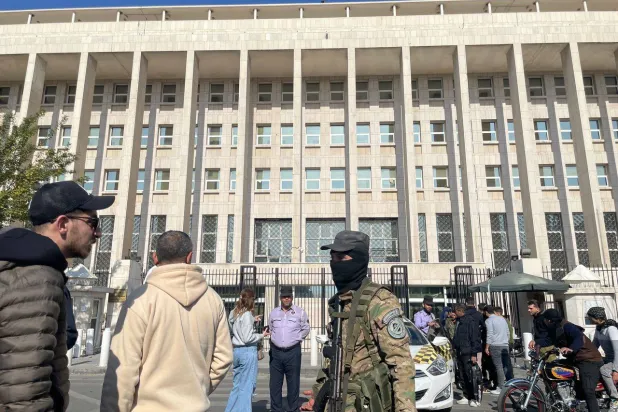 عناصر من «هيئة تحرير الشام» أمام المصرف المركزي السوري في دمشق (الشرق الأوسط)