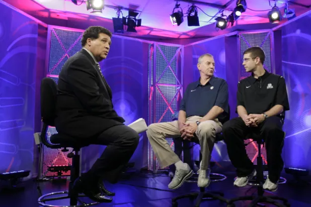  Greg Gumbel, left, watches as Connecticut head coach Jim Calhoun talks to Butler head coach Brad Stevens, right, prior to taping a television interview for the men's NCAA Final Four college basketball championship game Sunday, April 3, 2011, in Houston. (AP Photo/Eric Gay, File)